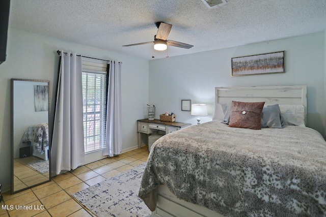 bedroom with ceiling fan, a textured ceiling, multiple windows, and light tile patterned floors