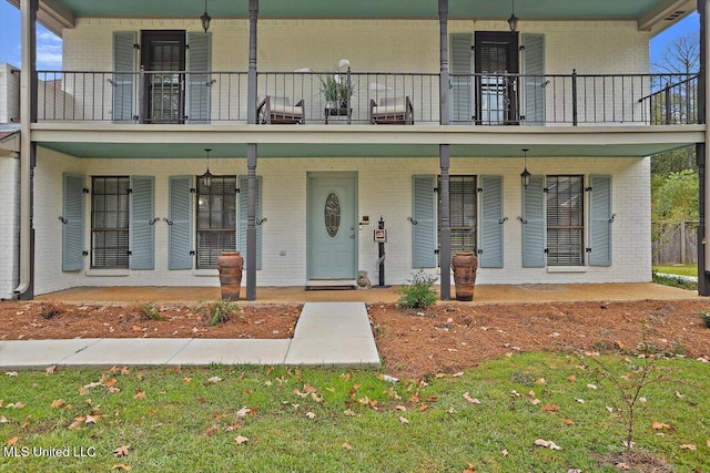 view of front of house with a front lawn and a balcony