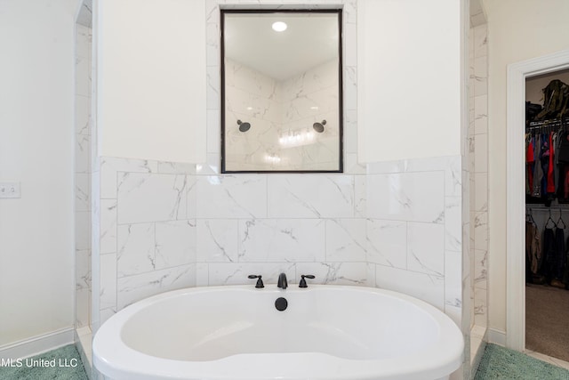 bathroom with tile walls and a bathtub