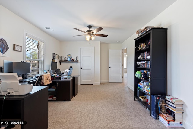 carpeted office space with ceiling fan