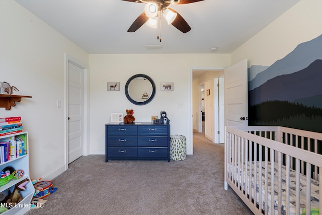 carpeted bedroom with a nursery area and ceiling fan