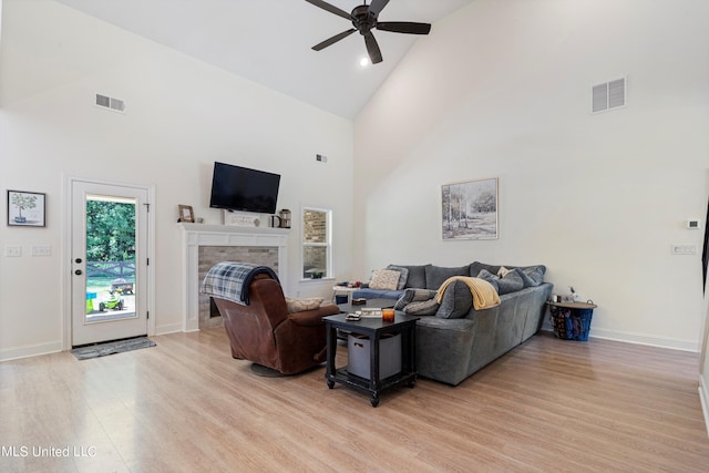 living room featuring ceiling fan, high vaulted ceiling, and light wood-type flooring