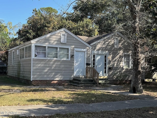 bungalow-style home featuring a front yard and crawl space