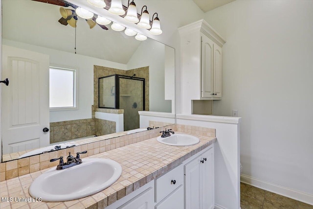 bathroom with double vanity, a sink, a stall shower, and toilet