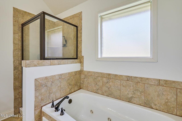 full bathroom featuring a tub with jets and a shower stall