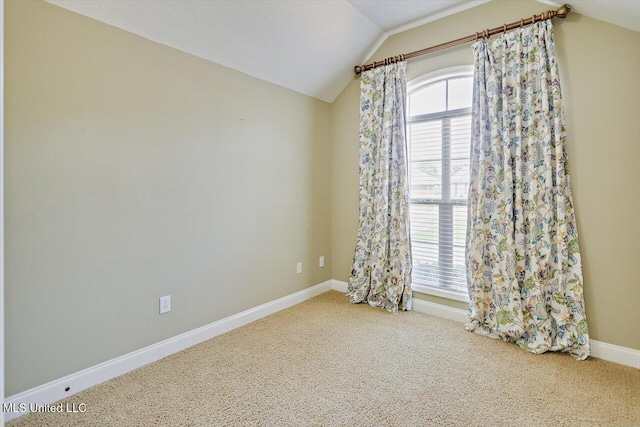 unfurnished room featuring carpet flooring, baseboards, and vaulted ceiling