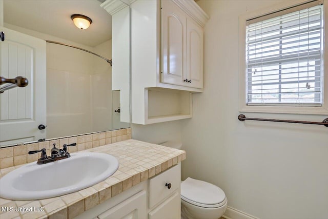 full bath featuring vanity, walk in shower, and toilet