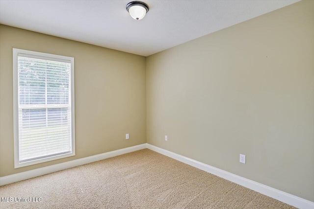 unfurnished room featuring baseboards and carpet