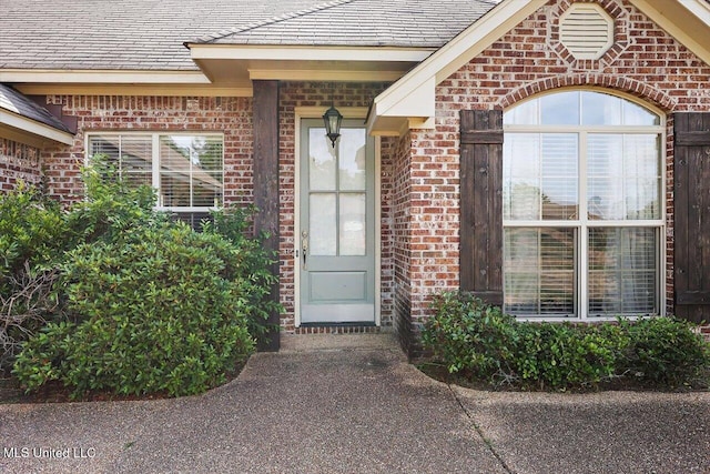 entrance to property featuring brick siding