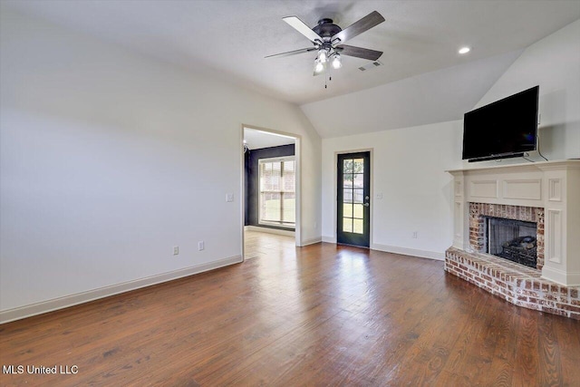 unfurnished living room with visible vents, a brick fireplace, wood finished floors, lofted ceiling, and ceiling fan