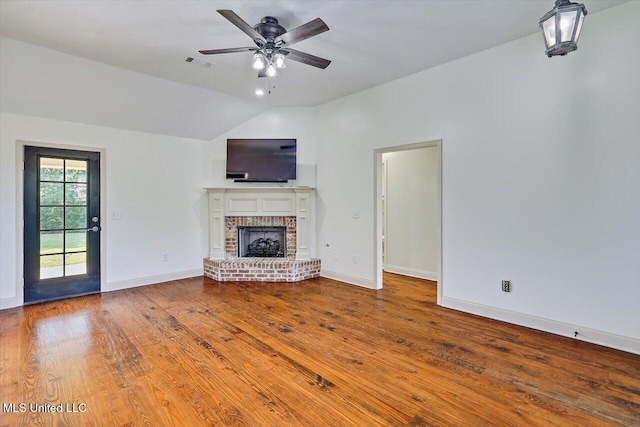 unfurnished living room featuring visible vents, wood finished floors, a fireplace, ceiling fan, and vaulted ceiling