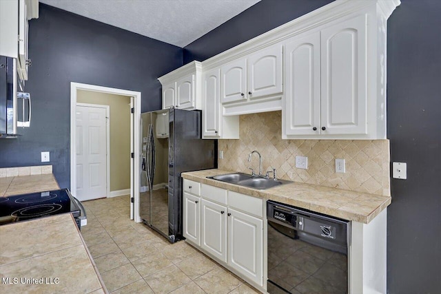 kitchen with a sink, decorative backsplash, black appliances, and white cabinets