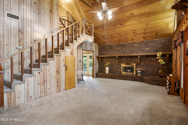48 Brady Rd, Petal, MS 39465 - unfurnished living room with a fireplace, carpet flooring, stairway, brick wall, and wood walls