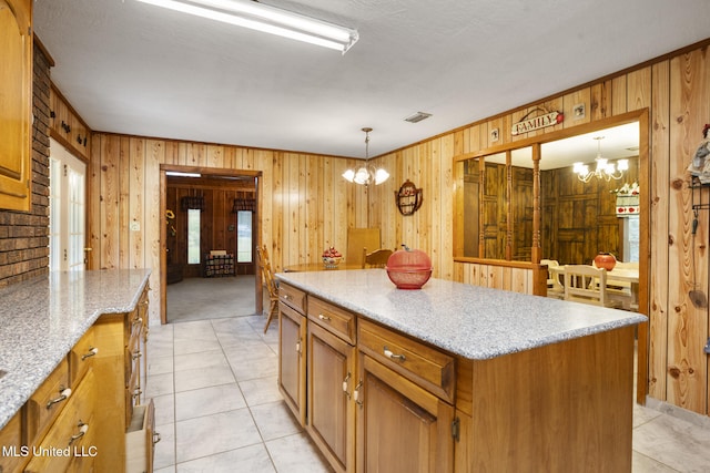 48 Brady Rd, Petal, MS 39465 - kitchen with a chandelier, wooden walls, a center island, pendant lighting, and brown cabinetry