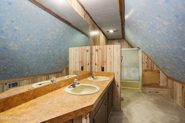 48 Brady Rd, Petal, MS 39465 - bathroom featuring wooden walls, wallpapered walls, lofted ceiling, double vanity, and a textured ceiling