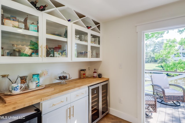 indoor dry bar featuring wine cooler and baseboards