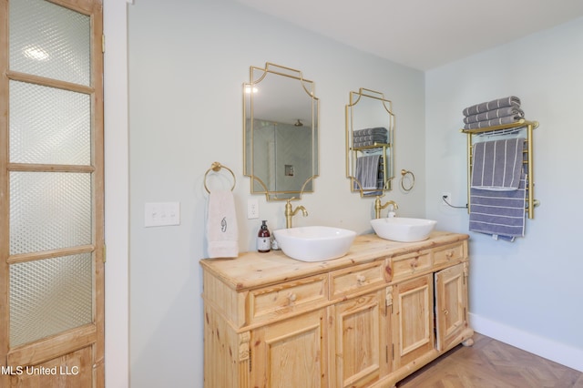bathroom with double vanity and baseboards