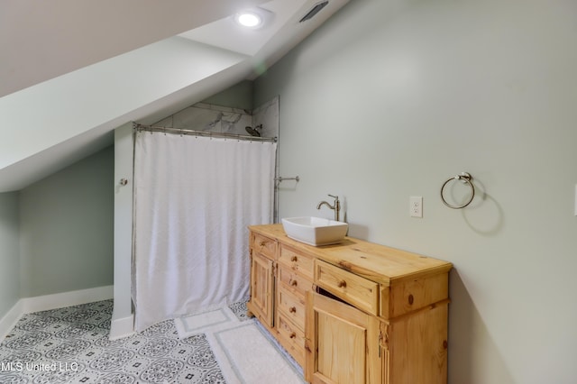 bathroom with a shower with curtain, baseboards, lofted ceiling, vanity, and tile patterned floors