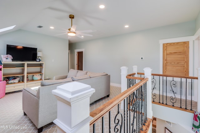 carpeted living area featuring a ceiling fan, recessed lighting, a skylight, and vaulted ceiling