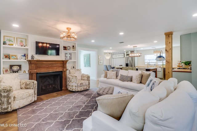 living area with a fireplace, a chandelier, and recessed lighting