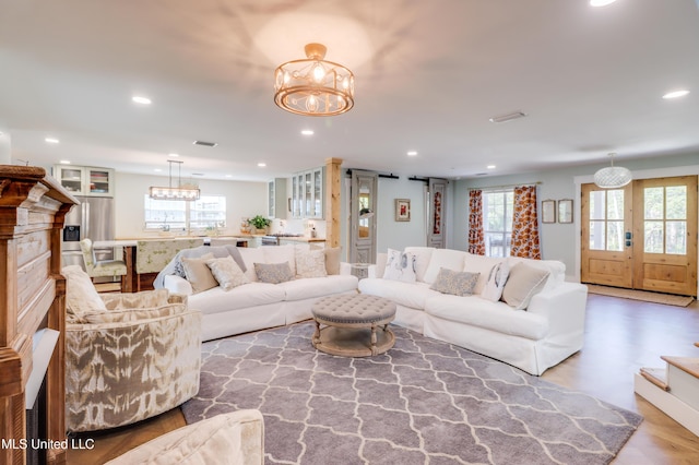 living room featuring a chandelier, recessed lighting, plenty of natural light, and wood finished floors