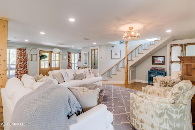 living room with recessed lighting, healthy amount of natural light, stairs, a chandelier, and baseboards
