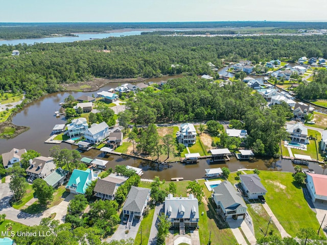aerial overview of property's location featuring a forest, nearby suburban area, and a large body of water