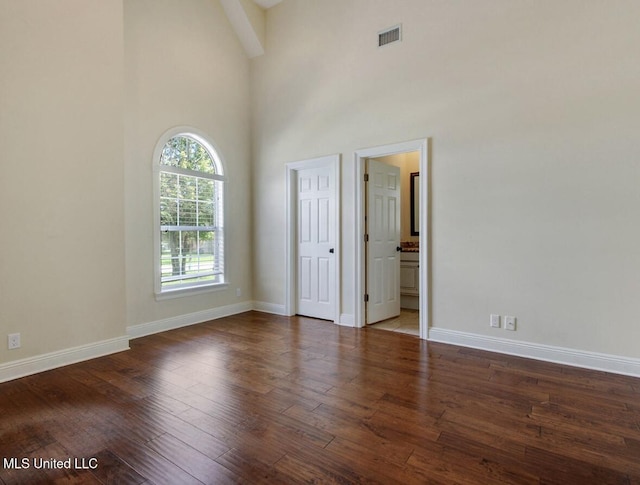 spare room featuring a high ceiling and dark hardwood / wood-style floors