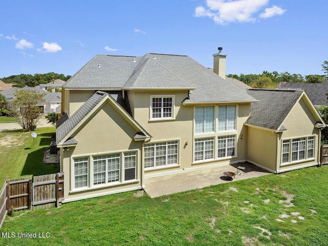 back of property with a yard and a patio area