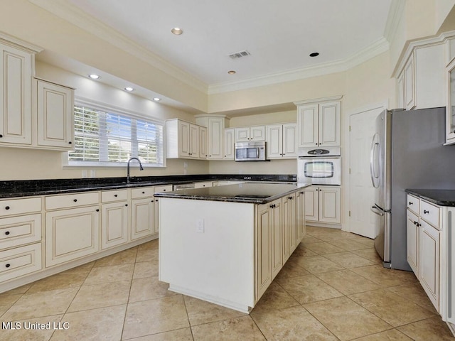 kitchen featuring crown molding, appliances with stainless steel finishes, a center island, and sink