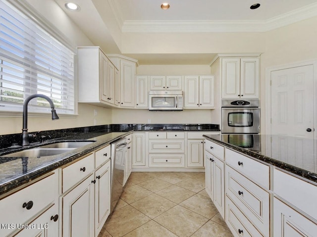 kitchen featuring white cabinetry, appliances with stainless steel finishes, sink, and dark stone countertops