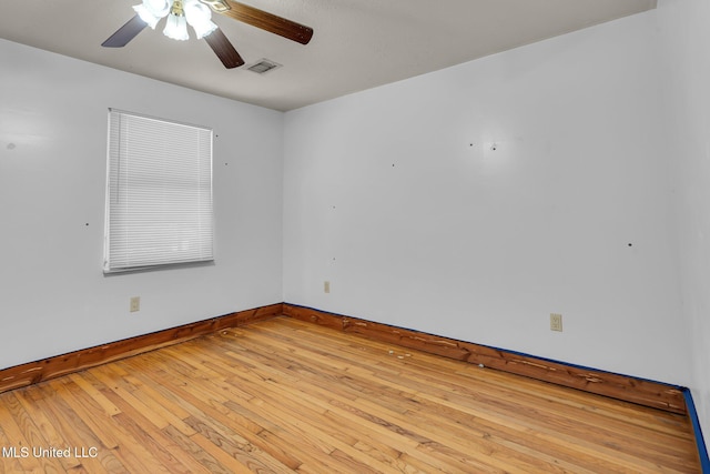spare room featuring baseboards, ceiling fan, and hardwood / wood-style flooring