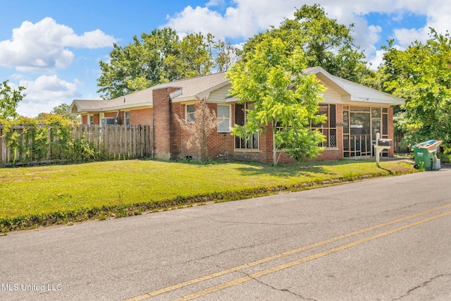 ranch-style home featuring brick siding and a sunroom