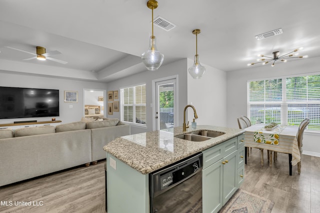 kitchen with dishwasher, a sink, light wood-style floors, open floor plan, and a kitchen island with sink