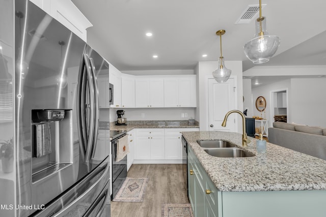 kitchen with black appliances, a sink, light wood finished floors, white cabinetry, and recessed lighting