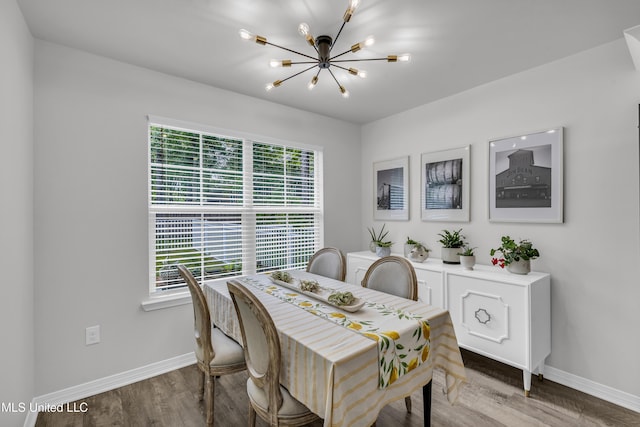 dining room featuring a chandelier, baseboards, and wood finished floors