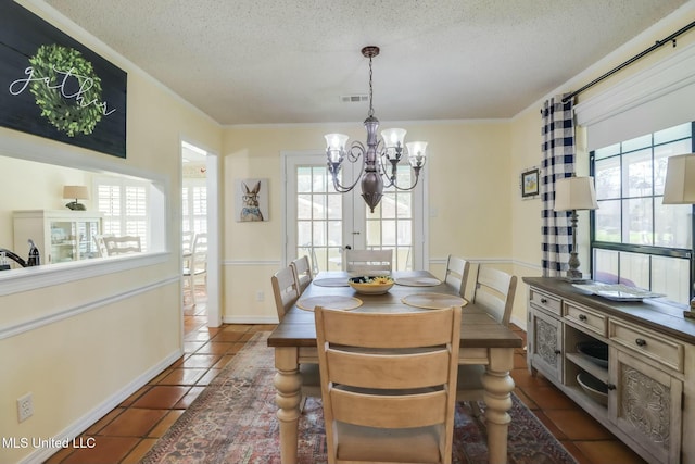 dining room with visible vents, a notable chandelier, dark tile patterned flooring, ornamental molding, and a textured ceiling