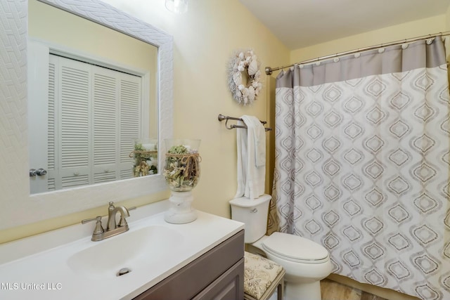 bathroom featuring curtained shower, toilet, and vanity