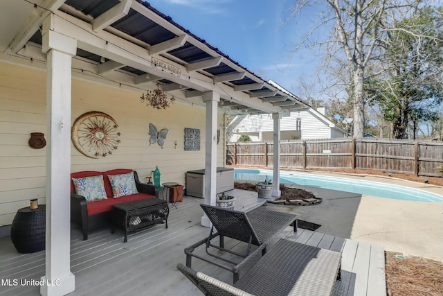 wooden deck with a fenced in pool, outdoor lounge area, and a fenced backyard