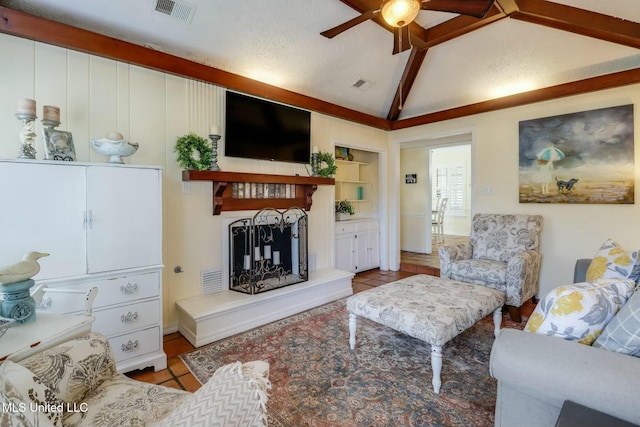 living room featuring visible vents, lofted ceiling, built in shelves, and a ceiling fan