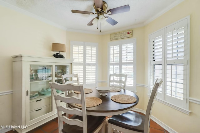 dining room with ornamental molding, baseboards, and ceiling fan