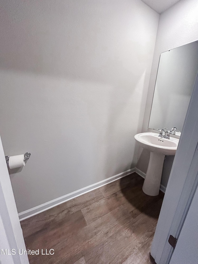 bathroom with a sink, baseboards, and wood finished floors