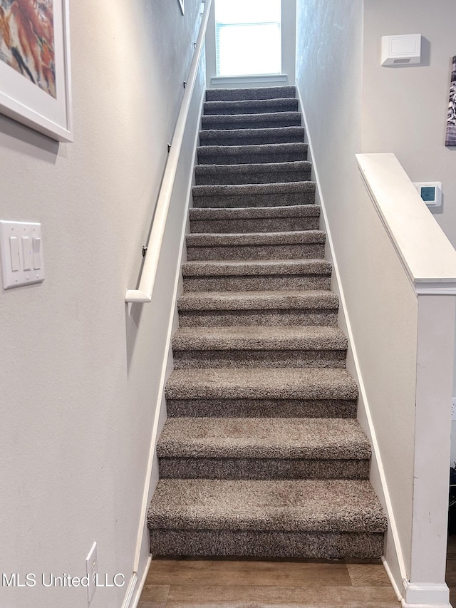 stairway with baseboards and wood finished floors