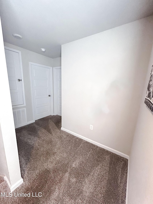 unfurnished room featuring baseboards and carpet