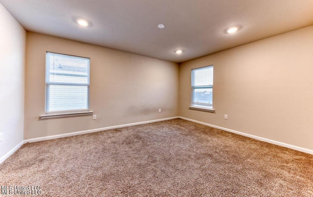 empty room featuring carpet flooring and baseboards