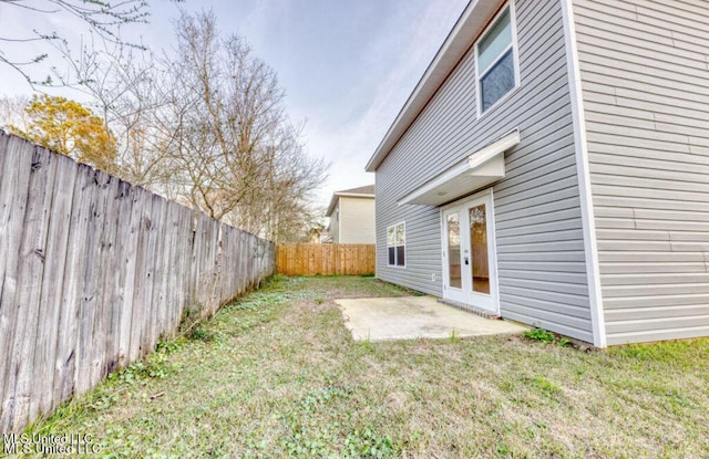 view of yard featuring french doors, a patio, and a fenced backyard