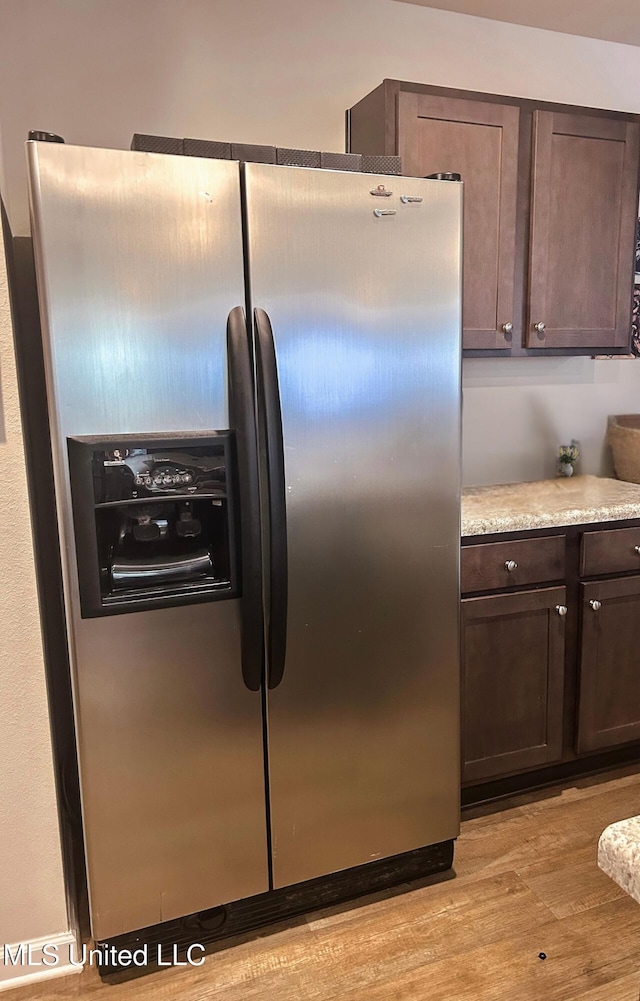 kitchen featuring dark brown cabinetry, light wood finished floors, light countertops, and stainless steel fridge with ice dispenser