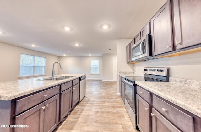 kitchen with a sink, recessed lighting, stainless steel appliances, light countertops, and baseboards