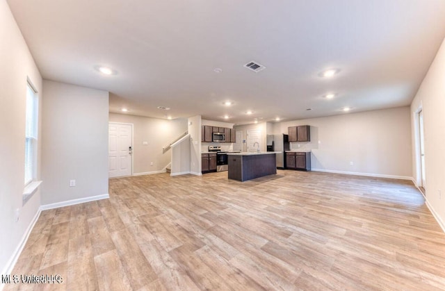 unfurnished living room with recessed lighting, baseboards, visible vents, and light wood-type flooring