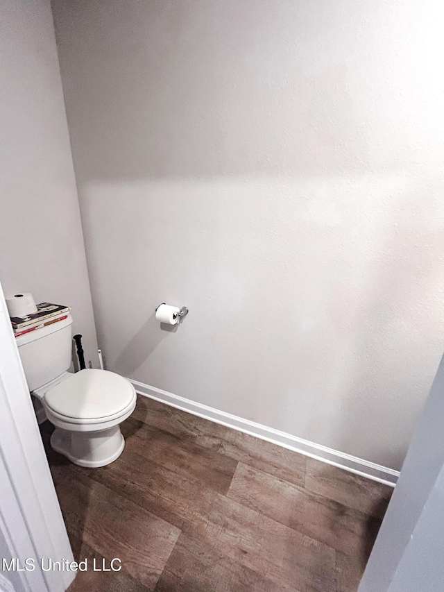 bathroom featuring baseboards, toilet, and wood finished floors